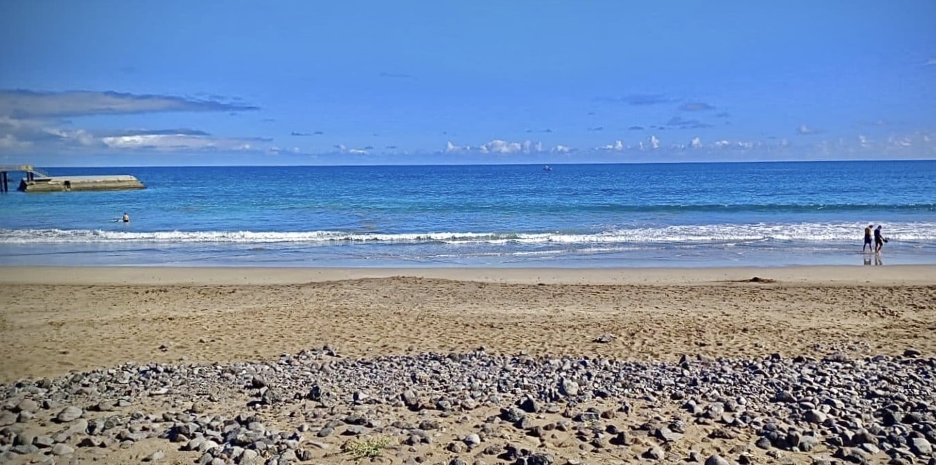 Paseantes y bañistas en la Playa de La Garita, Arrieta.