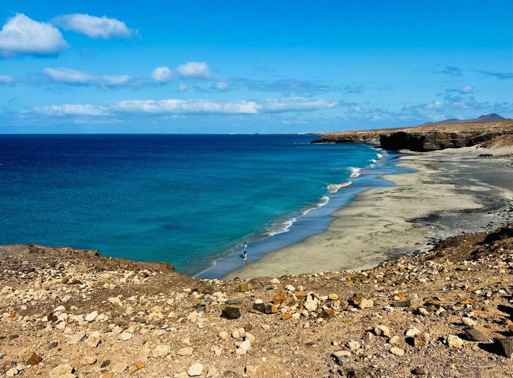 Playa paradisiaca, pescador y la Punta de Jandía en el horizonte. Fotografía: Lanzarote3.com