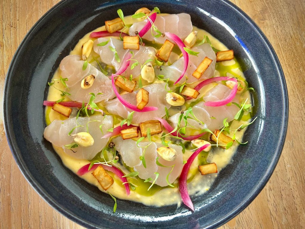 Tiradito de cherne marinado, crema de millo tostado y mojo verde.